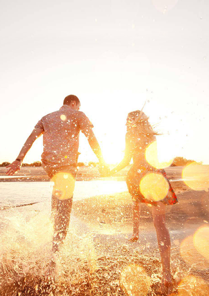 hombre y mujer en la playa agarrados de la manos 